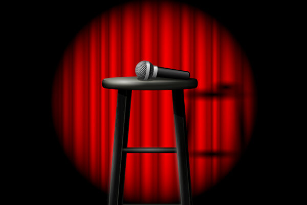 Stand up comedy show - microphone and stool in ray of spotlight and drop-curtain